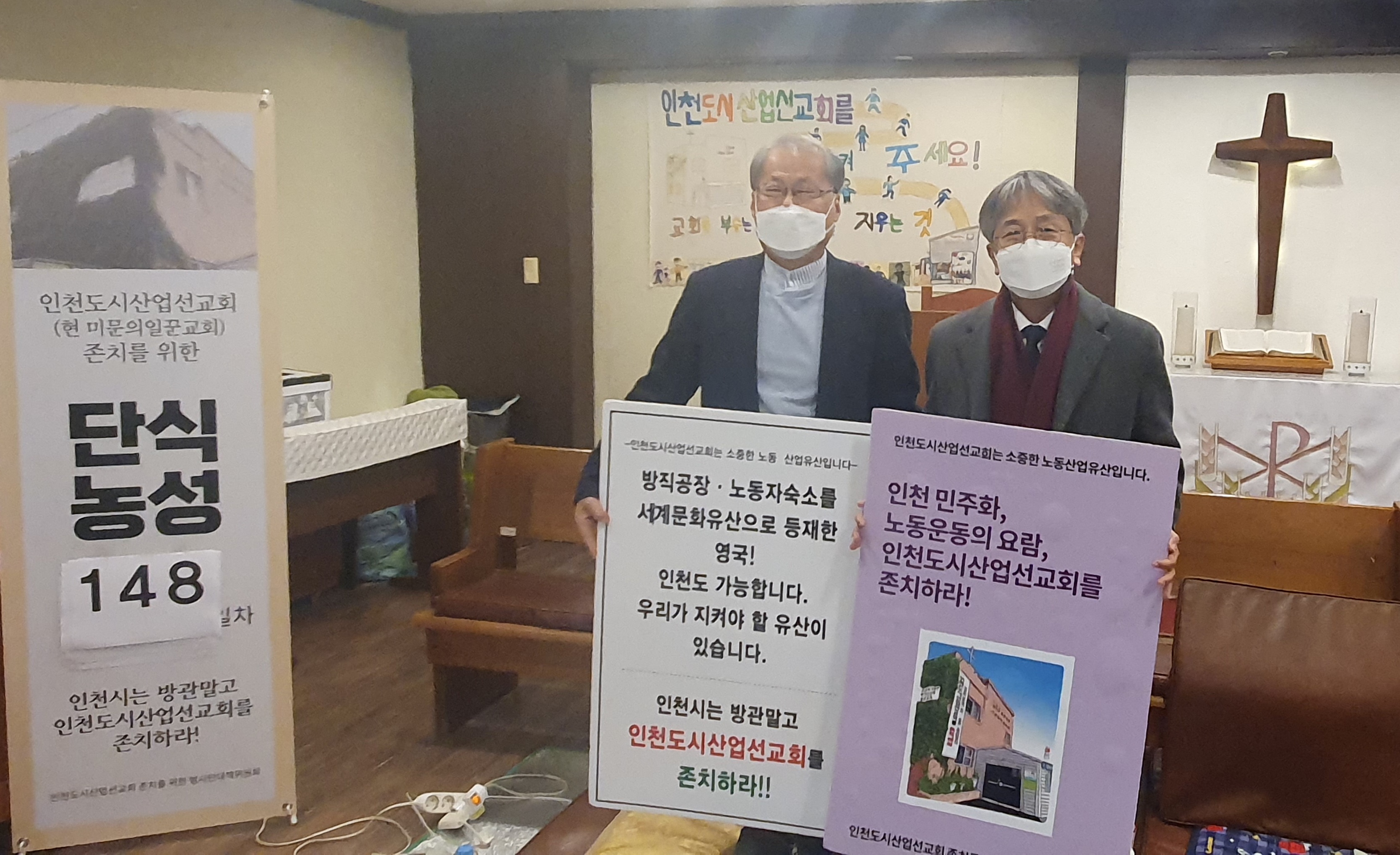 인천산선 존치를 위한 피켓을 들고 사진을 촬영하고 있는 이민우 범대위 실행위원장과 강성구 상임부이사장의 사진