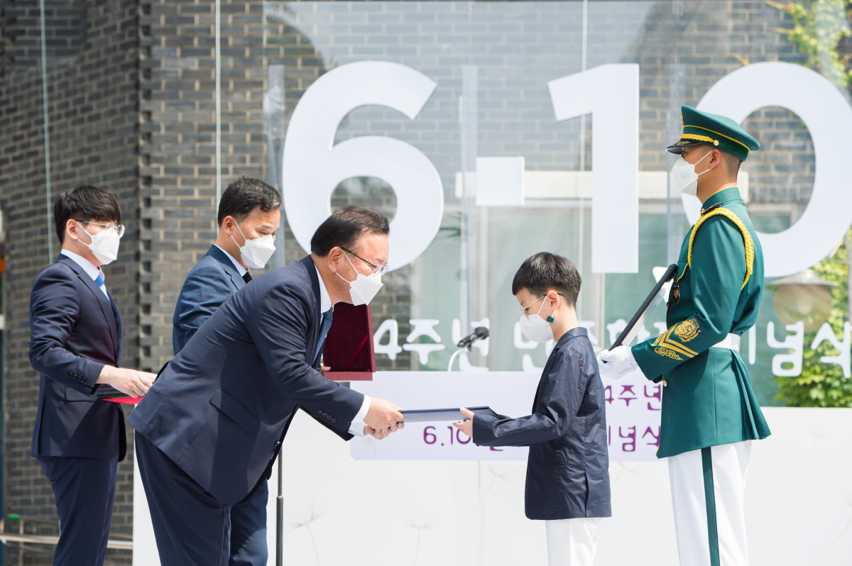 김부겸 국무총리가 고 계훈제 선생 손자 계리에게 국민훈장을 전수하고 있다