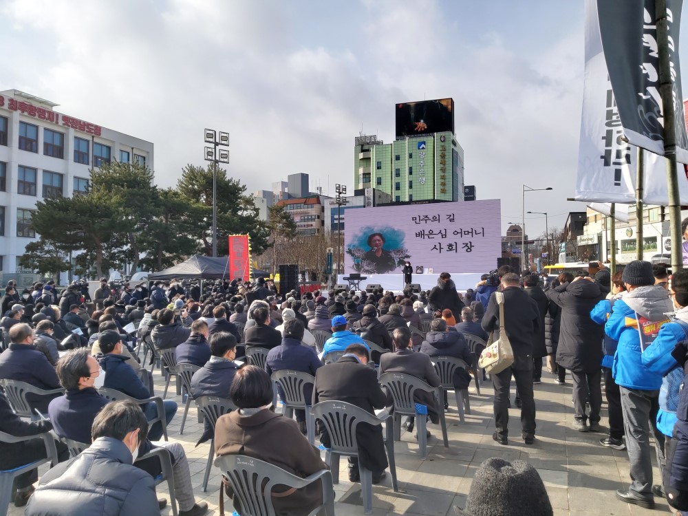 광장에 사람들이 스크린을 향해 앉아 노제에 참여하는 모습